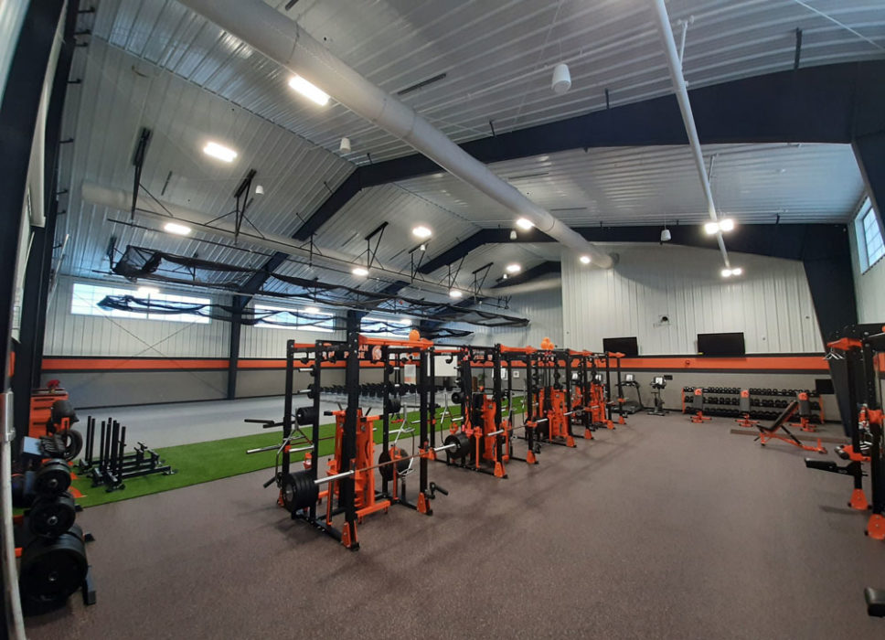 View of weights and interior turf in training center for school.