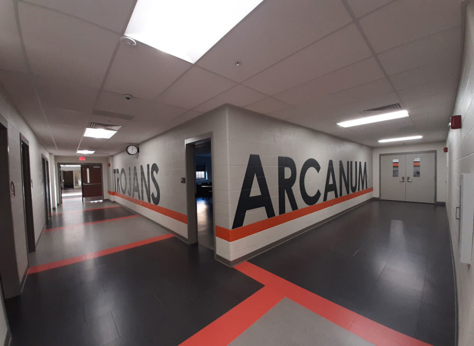 Interior of finished school building with painted walls saying Arcanum Trojans.