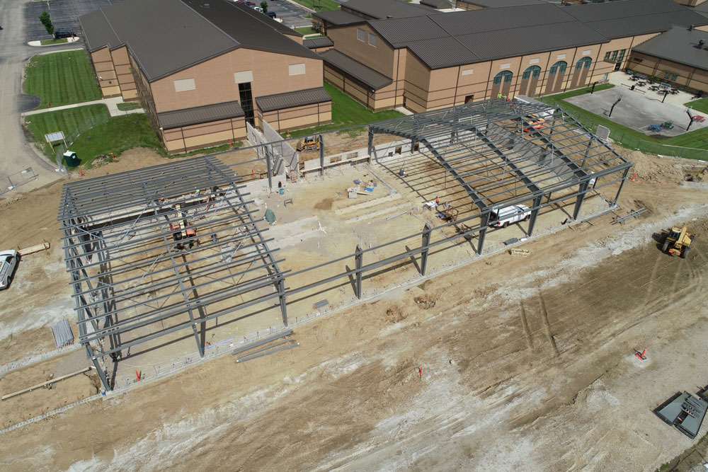 Aerial view of unfinished school building with exposed beams.