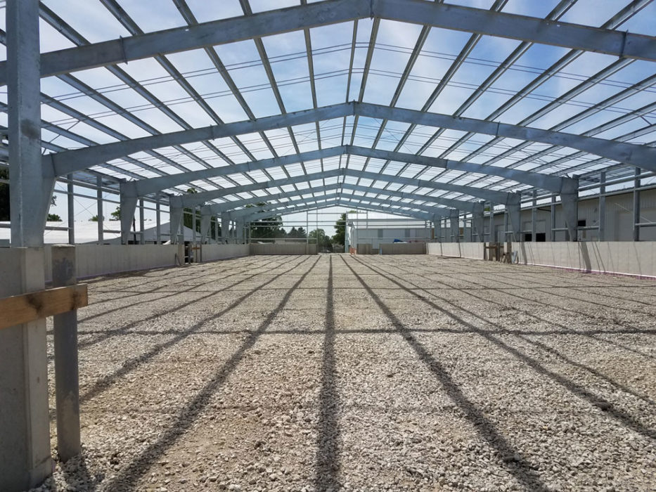 Interior of incomplete steel building with open rafters.