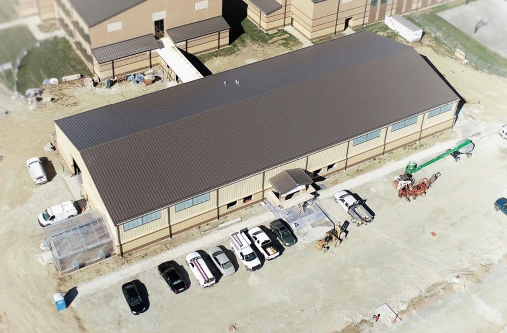 Overhead view of finished school building and cars outside.