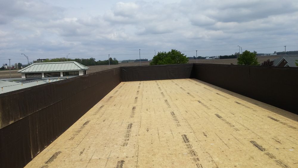 View of roof showing exposed sheathing and parapet walls.