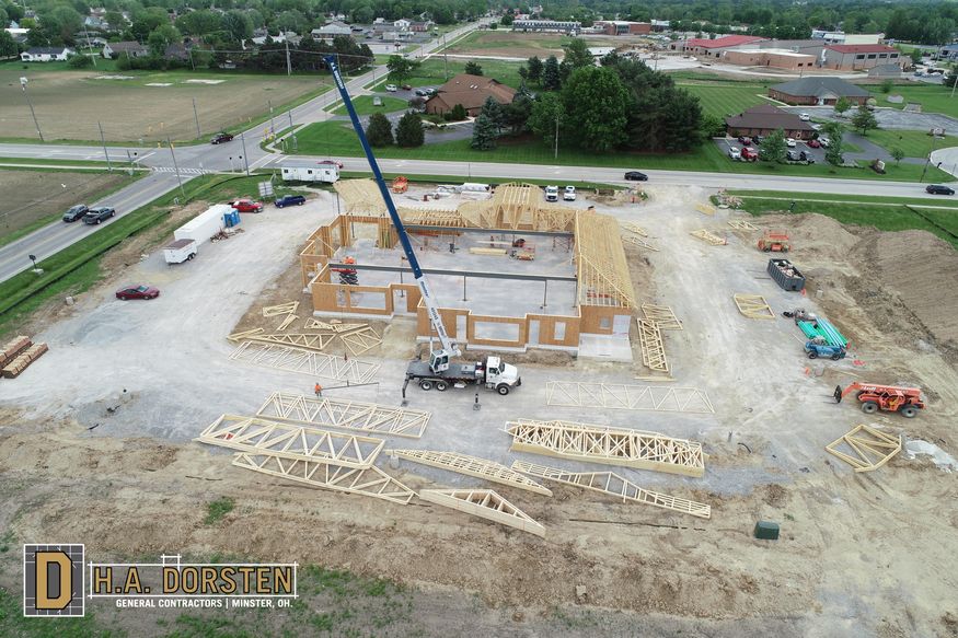 Aerial view of wood trusses being set in place with a crane.