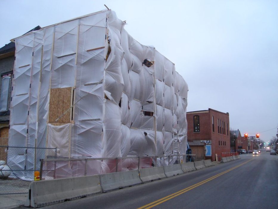 Masonry tented on exterior of commercial office building preparing for cold-weather conditions.