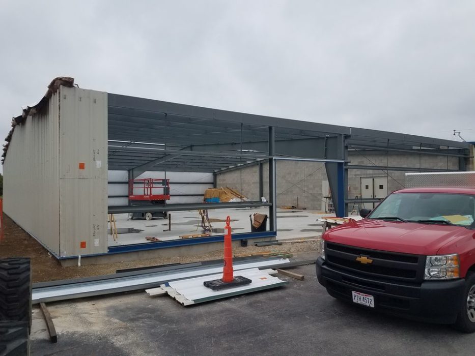 Metal wall panels being installed on custom-engineered metal building.